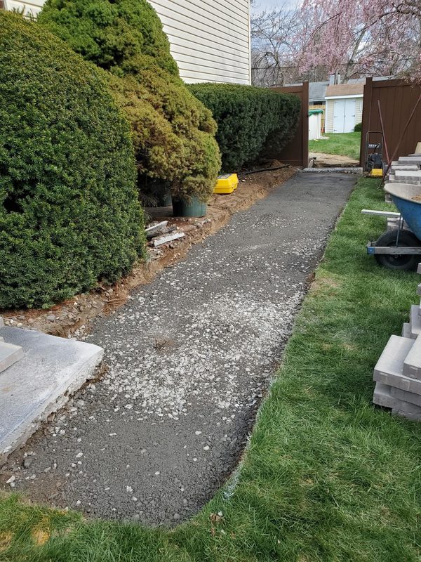 Excavated path between fences for slate walkway